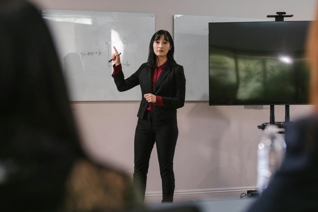 Woman presenting at a business meeting, engaging with the audience in a corporate setting.
