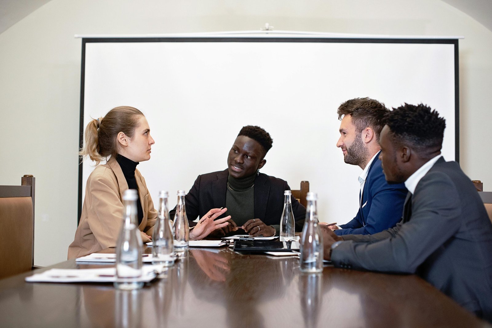 A diverse group of professionals engaged in a business meeting in an office setting.